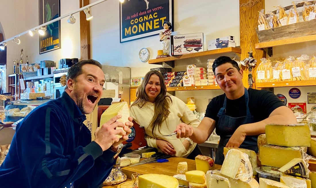 Brian hamming it up with a wedge of cheese at a cheese shop