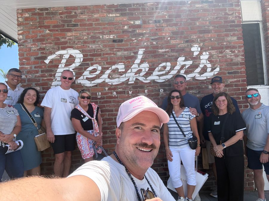 Brian taking a group selfie at the Becker's Bakery wall