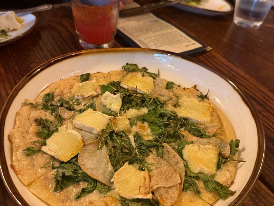 A flatbread with brie, pear, and arugula