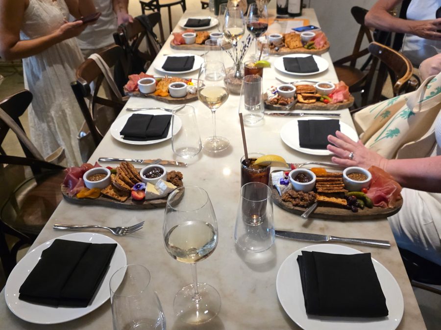 A long table set with charcuterie boards and wine