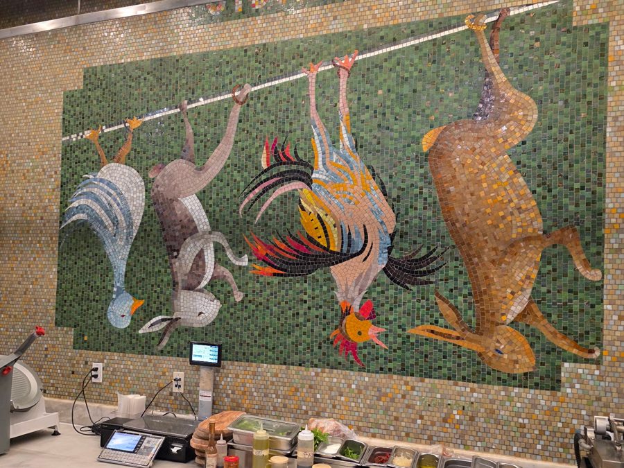 A mosaic mural above a gourmet deli counter